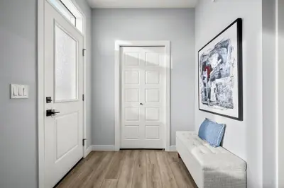 a living room with a white door and a couch at Modern 4BR Retreat 3 Baths Near to Banff&Airport in Calgary