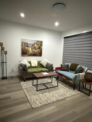 a living room with a couch and a table at Slice of Heaven! 3 Bdrm Duplex 10 minutes drive to Spruce Meadows, with easy access to Stampede and Banff, CENTRAL AC available Mid Spring 2026! in Calgary