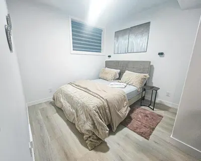 a small bedroom with a bed and a table at Ebenz Apartment in Calgary