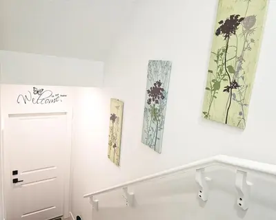 a white room with two pictures on the wall at Ebenz Apartment in Calgary