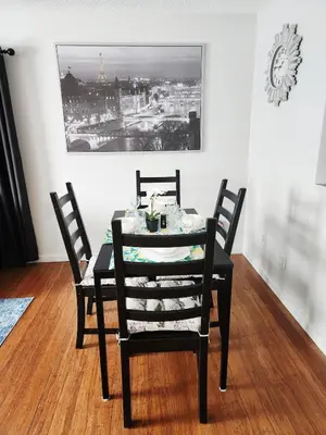 a dining room table with two chairs and a clock on the wall at House in Edmonton