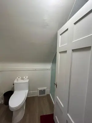a bathroom with a white toilet and a door at Vancouver Airport Rooms - Free Parking, Fast WiFi, Near Transit in Vancouver