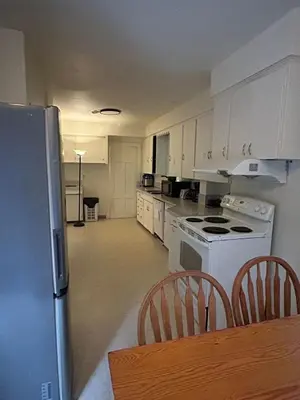 a kitchen with white appliances and a table and chairs at Vancouver Airport Rooms - Free Parking, Fast WiFi, Near Transit in Vancouver