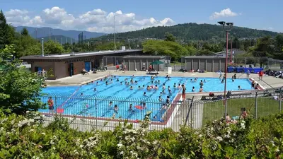 a large swimming pool with many people in it at Cozy 2BR 1BA Retreat in Vibrant Vancouver in Vancouver