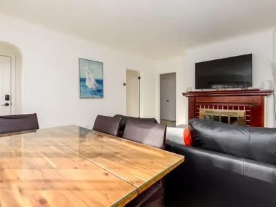 a dining room with a wooden table and leather chairs at Cozy 2BR 1BA Retreat in Vibrant Vancouver in Vancouver
