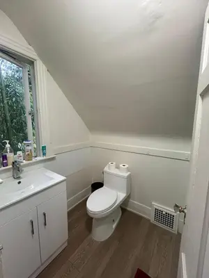 a white bathroom with a toilet and a sink at Vancouver Budget Rooms Near Beach & Transit - Fast WiFi & Free Parking in Vancouver