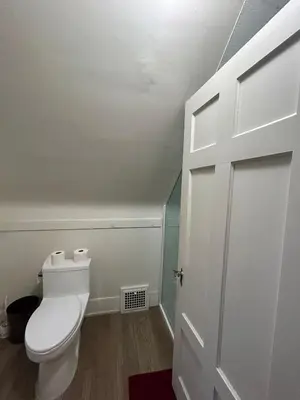 a bathroom with a toilet and a white door at Vancouver Budget Rooms Near Beach & Transit - Fast WiFi & Free Parking in Vancouver