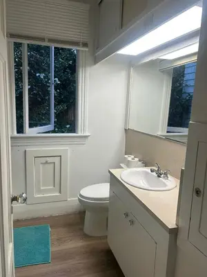 a bathroom with a toilet and a sink and a mirror at Vancouver Budget Rooms Near Beach & Transit - Fast WiFi & Free Parking in Vancouver
