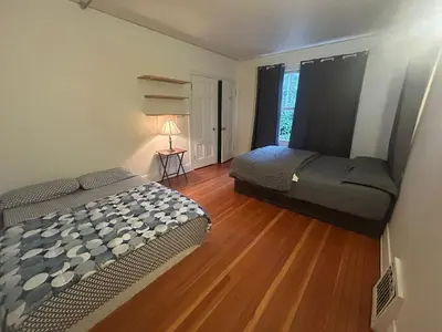 a bedroom with two beds and a wooden floor at Budget Vancouver Rooms Near YVR - Free Parking, Fast WiFi in Vancouver
