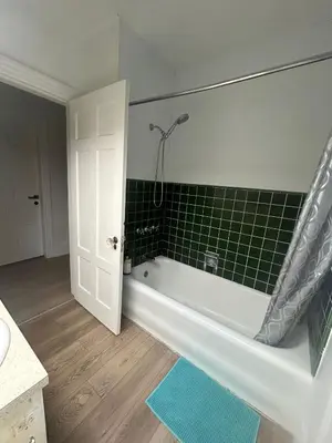 a bathroom with a tub and a green tiled wall at Budget Vancouver Rooms Near YVR - Free Parking, Fast WiFi in Vancouver