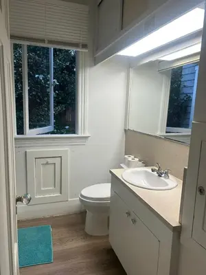 a bathroom with a toilet and a sink and a mirror at Vancouver Airport & UBC Private Rooms - Free Parking, Fast Wifi in Vancouver
