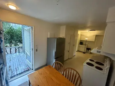 a kitchen with a refrigerator and a table with chairs at Vancouver Airport & UBC Private Rooms - Free Parking, Fast Wifi in Vancouver