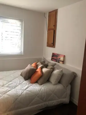 a bed with many pillows on it in a room at Quiet-comfy 3 bedroom house on a tree lined street in Kitsilano in Vancouver