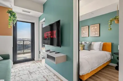 a bedroom with a bed and a tv on a wall at Spacious and elegant| 2 Kng Beds| Space for all in Calgary
