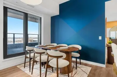 a dining room with a blue wall and a table and chairs at Spacious and elegant| 2 Kng Beds| Space for all in Calgary