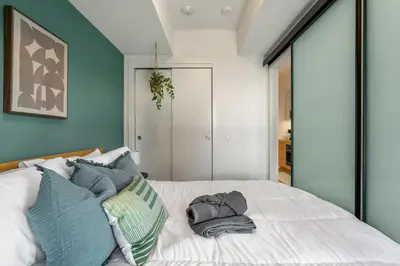 a bedroom with a white bed with blue walls at Spacious and elegant| 2 Kng Beds| Space for all in Calgary