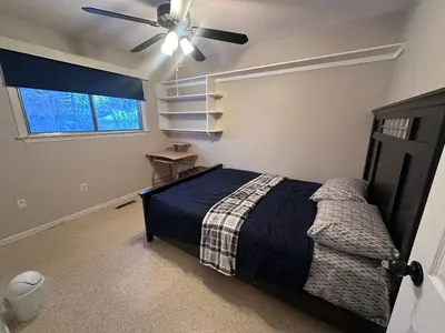 a bedroom with a bed and a ceiling fan at Cozy West Edmonton Home Near Jasper Park & shops in Edmonton