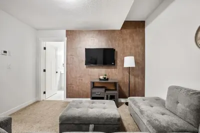 a living room with a couch and a tv at Spacious Modern 3 Bedroom Basement Suite in Calgary