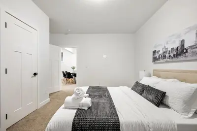 a bedroom with a large bed with a stuffed animal on it at Spacious Modern 3 Bedroom Basement Suite in Calgary