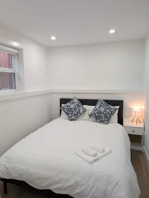 a bedroom with a white bed with two towels on it at Modern 2BR Suite Steps to SkyTrain in Vancouver