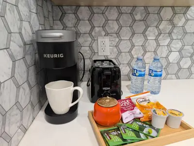 a coffee maker on a counter with a tray of food at Modern 2BR Suite Steps to SkyTrain in Vancouver