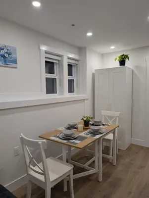 a dining room with a table and chairs at Modern 2BR Suite Steps to SkyTrain in Vancouver
