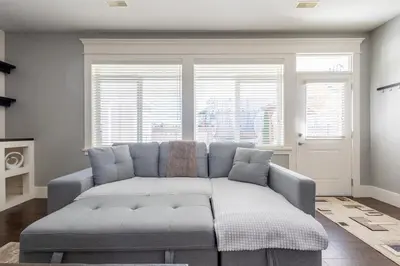 a living room with a couch in front of two windows at Beautiful abode in Abbotsford in Abbotsford