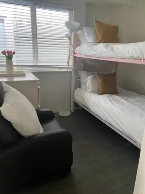 a living room with two bunk beds and a chair at Quiet-comfy 3 bedroom house on a tree lined street in Kitsilano in Vancouver