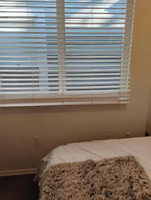 a bedroom with a bed and a window with blinds at Quiet-comfy 3 bedroom house on a tree lined street in Kitsilano in Vancouver