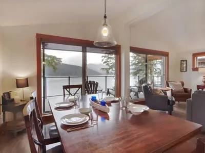a dining room with a table and a view of the ocean at Wickham's Wake - 3BR Oceanfront - pet friendly in Port Renfrew
