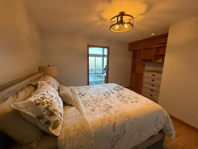 a bedroom with a bed with a white comforter at Woodhaven - Entire Home, Ocean Front in Bowser