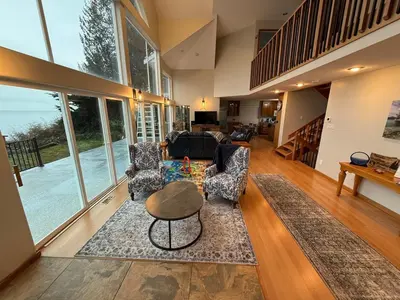 a living room with two chairs and a table at Woodhaven - Entire Home, Ocean Front in Bowser