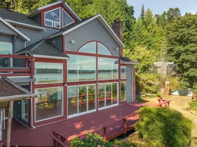 a house with large glass windows on the front of it at Woodhaven - Entire Home, Ocean Front in Bowser