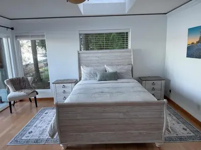 a bedroom with a large bed and a window at Woodhaven - Entire Home, Ocean Front in Bowser