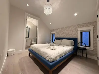 a bedroom with a large bed with a blue frame at YVR3106 | Cozy 3BR in Central Vancouver | 15 min to Downtown in Vancouver