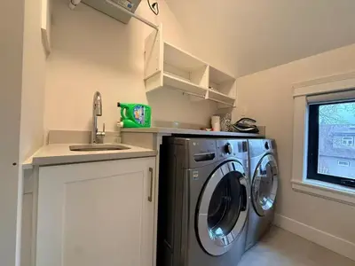 a small kitchen with a washing machine and a sink at YVR3106 | Cozy 3BR in Central Vancouver | 15 min to Downtown in Vancouver