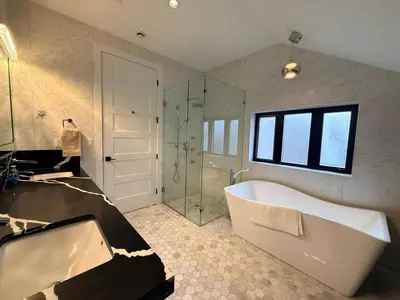 a bathroom with a tub and a glass shower at YVR3106 | Cozy 3BR in Central Vancouver | 15 min to Downtown in Vancouver