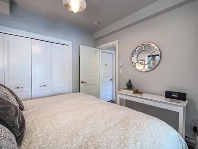 a bedroom with a large bed and a mirror at Oceanfront Suite with Hot Tub - No Pets - Sleep 4 in Port Renfrew