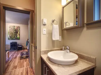 a bathroom with a sink and a mirror at Explorer's Retreat Sauna & Bunkhouse & Fire pit in Port Renfrew