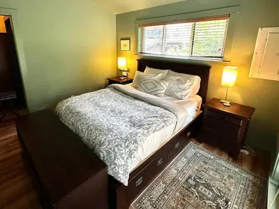 a bedroom with a bed with two night stands and a window at Hot Tub - Large Fully Enclosed deck - Pet Friendly in Port Renfrew