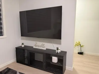 a living room with a television on a wall at Cozy 3 beds 2 and half baths 2 Story Home in Calgary