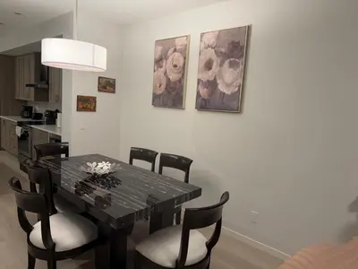 a dining room with a black table and chairs at Cozy 3 beds 2 and half baths 2 Story Home in Calgary