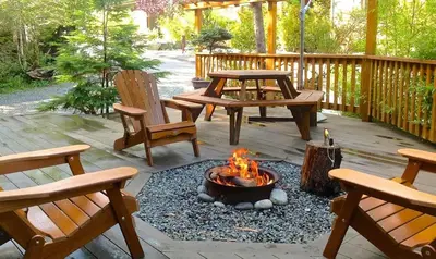 a fire pit on a patio with two benches at French Girl's Lair - Pet Friendly - Garden View in Port Renfrew
