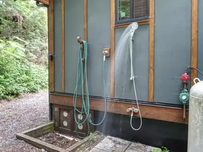 a bathroom with two showers on the side of a house at French Girl's Lair - Pet Friendly - Garden View in Port Renfrew
