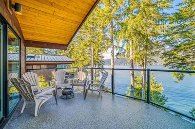 a porch with chairs and a view of the water at Seaside Haven -Hot Tub with Oceanfront View in Port Renfrew
