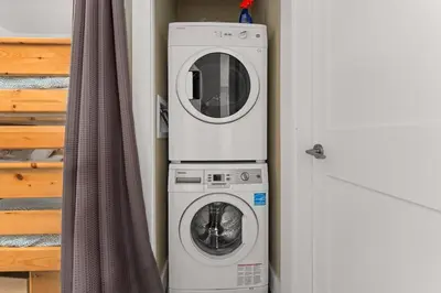 a washer and a washing machine next to a door at Seaside Haven -Hot Tub with Oceanfront View in Port Renfrew