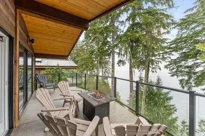 a patio with chairs and a table and a fire pit at Seaside Haven -Hot Tub with Oceanfront View in Port Renfrew