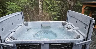 a hot tub in the middle of a yard at Enclosed deck - Hot tub - Pet Friendly- gas stove in Port Renfrew