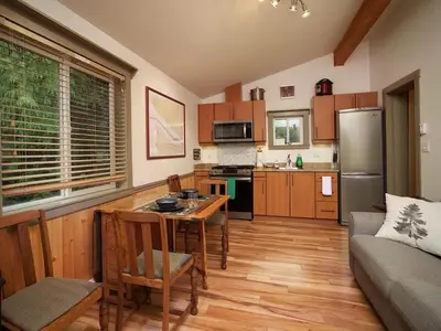a kitchen and living room with a table and a couch at Enclosed deck - Hot tub - Pet Friendly- gas stove in Port Renfrew