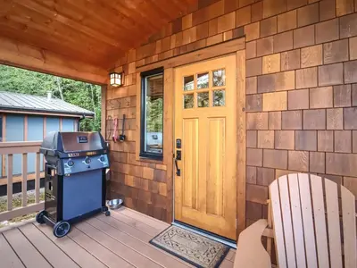 a grill on a deck next to a door at Enclosed deck - Hot tub - Pet Friendly- gas stove in Port Renfrew